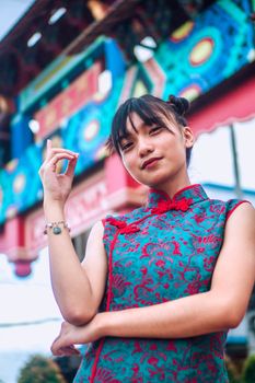 一位年轻女子身着传统亚洲服装，在户外城市环境中自信摆姿，展现了现代风格与文化