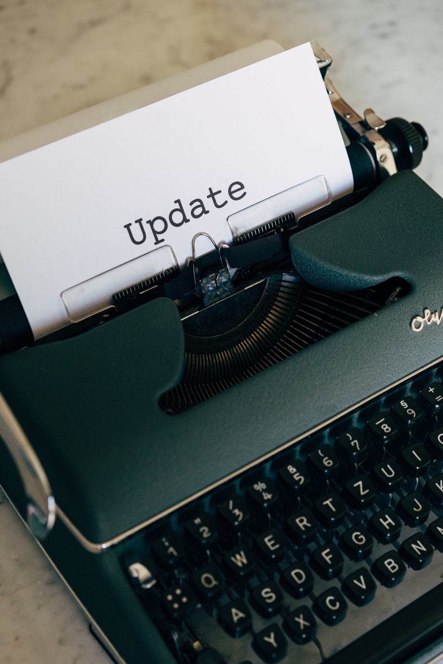 A close-up of a vintage typewriter with paper displaying the word 'Update'.