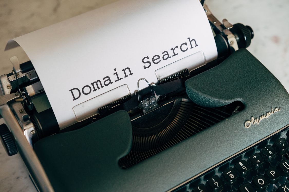 Pisaći stroj s papirom na kojemu piše Domain Search