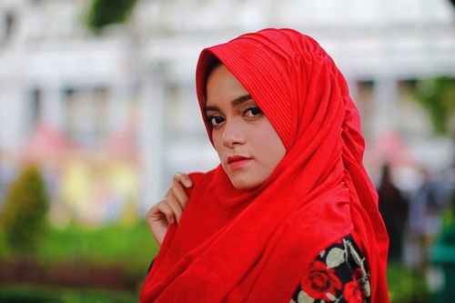 Free Portrait of a fashionable woman in vibrant red hijab outdoors, showcasing beauty and style. Stock Photo