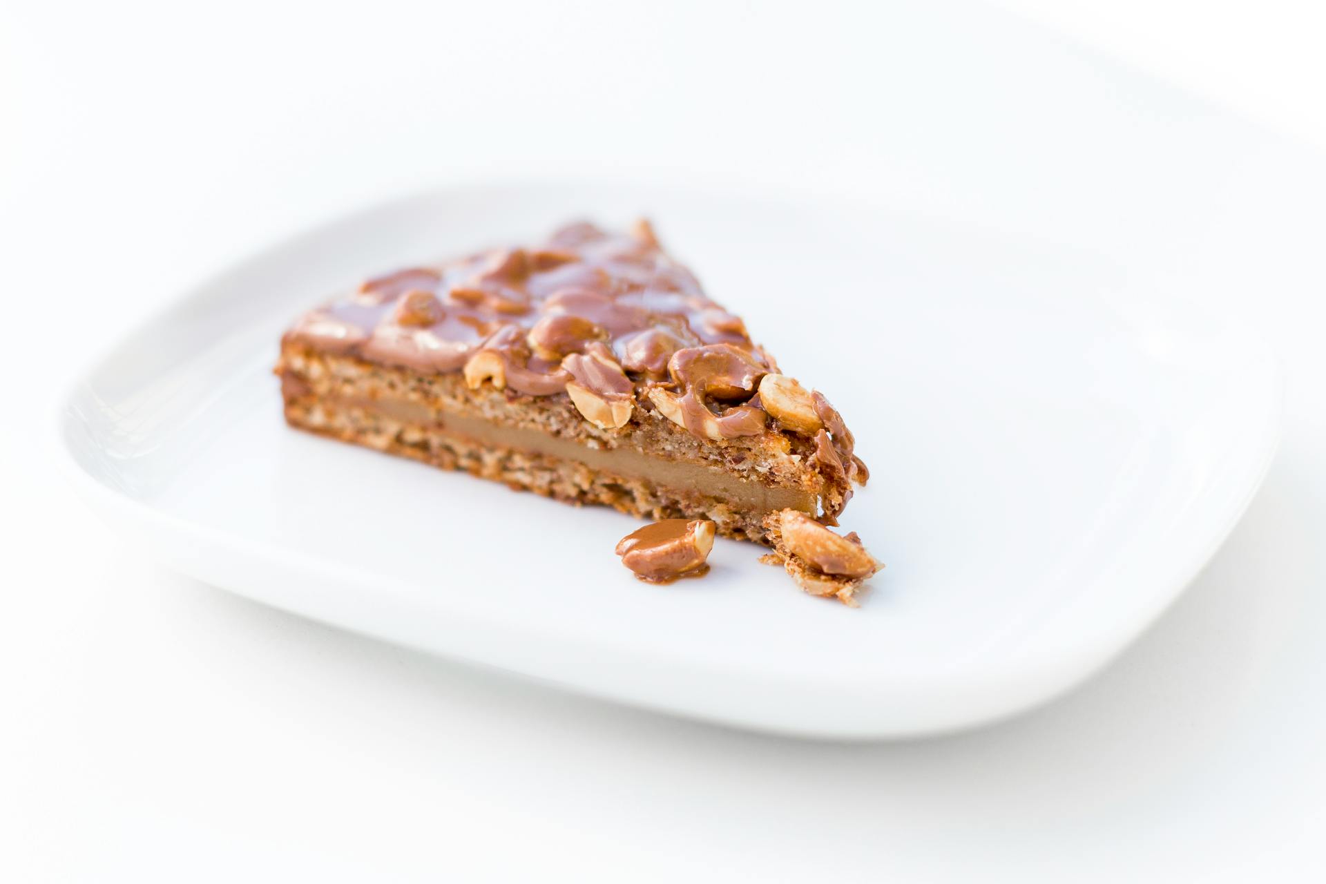 A Slice of Caramel Cake With Chocolate Coated Nuts