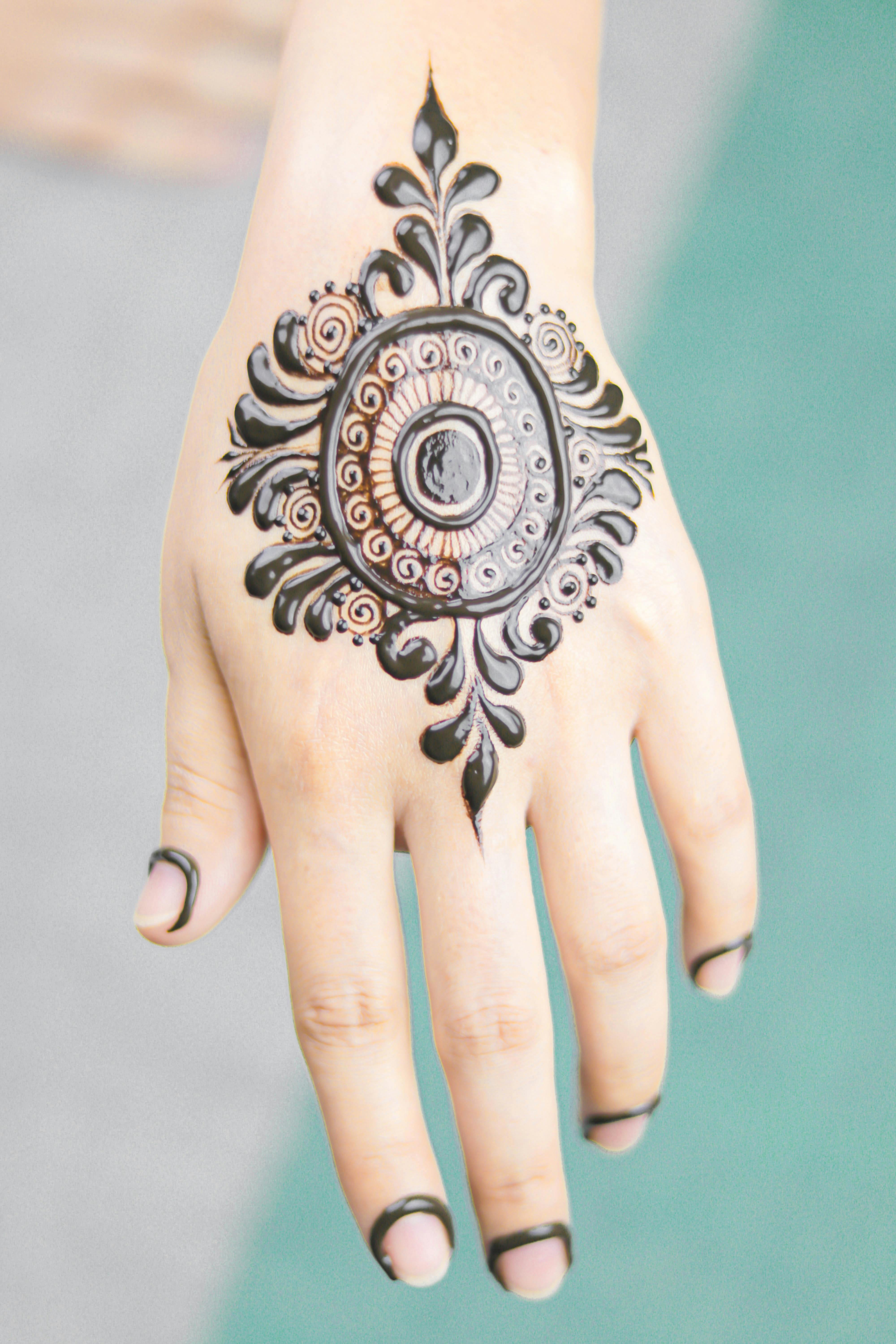 Henna tattoo Small henna tattoo in the form of the sun on the hand of a  girl Stock Photo  Adobe Stock
