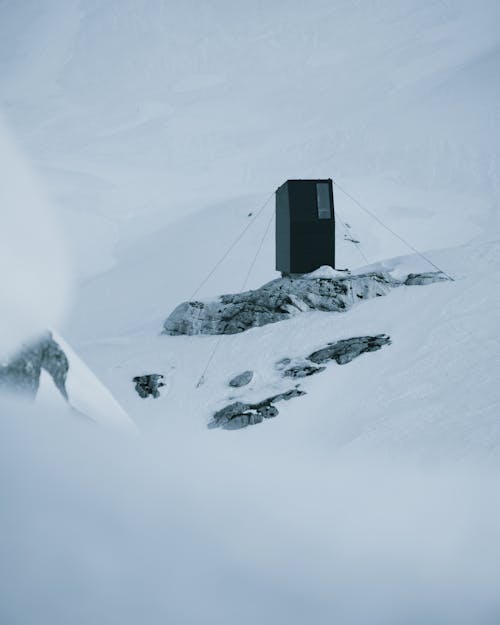 Expedition booth placed on stone on snowy mountain slope