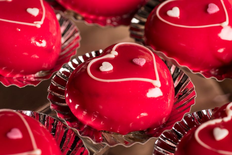 Delicious heart-shaped red cakes with white icing, perfect for Valentine's Day celebrations.