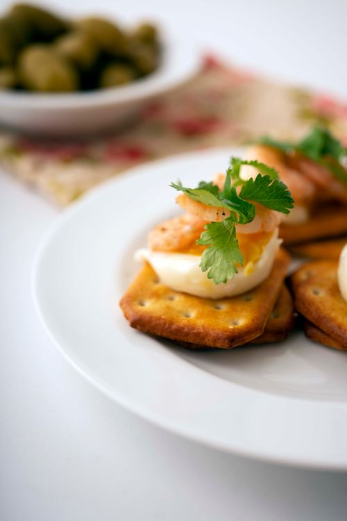 Free Delicious shrimp appetizers served on crackers with herbs, perfect for any gathering. Stock Photo