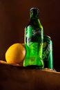 Green and Yellow Lemon Beside Green Bottle