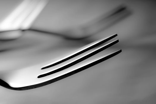 Artistic black and white close-up of shiny stainless steel forks with a modern touch.