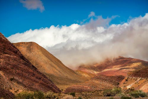 Rainbow mountains under white clouds on sunny day