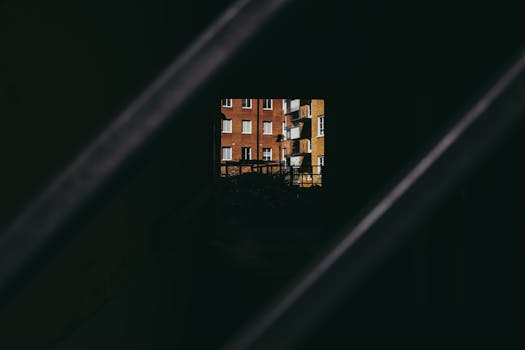 View of Stockholm apartment buildings framed through a modern gate on a moody day, showcasing urban architecture.