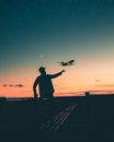 Silhouette of Man and Woman Standing on Dock during Sunset