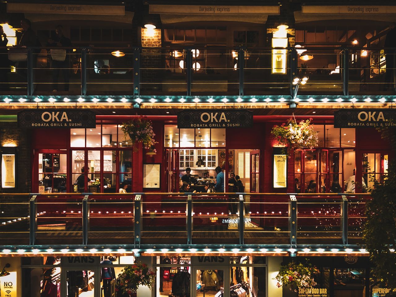 a lively nighttime scene at a shopping mall in the uk showcasing illum