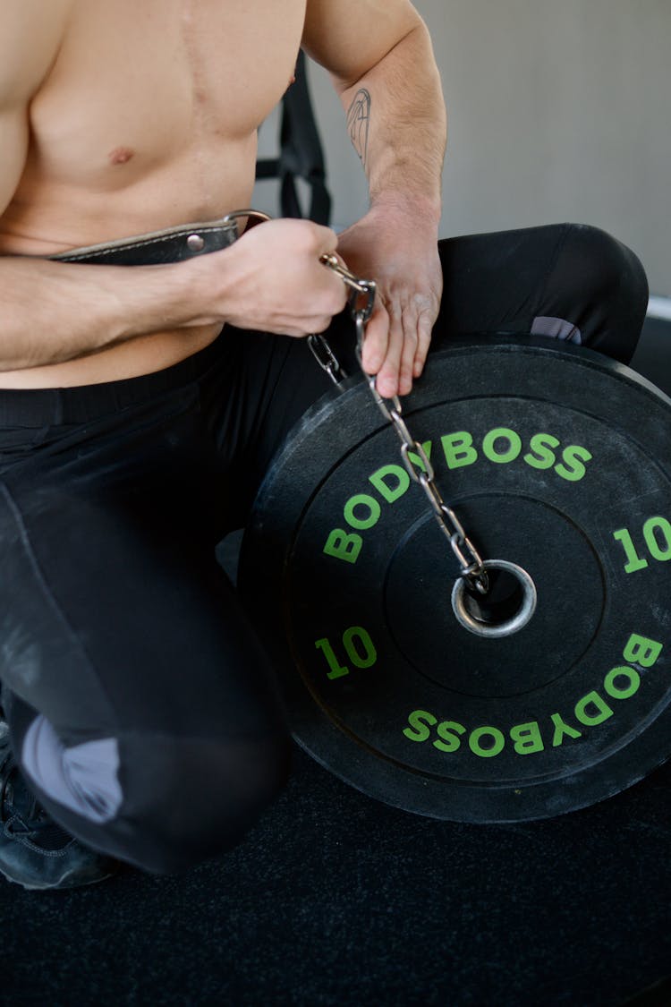 Man Putting A Chain On A Weight