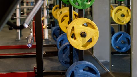 Vibrant colored weight plates stacked in a modern gym setting.