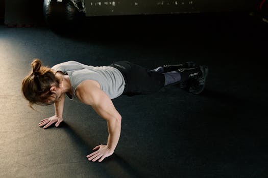 Adult male performing push-ups on gym floor, showcasing fitness and strength.