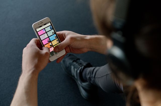 A phone showing a music streaming playlist with headphones