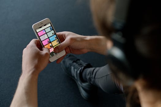 Person With Headphones Holding a Smartphone