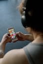 Person With Headphones Holding a Smartphone