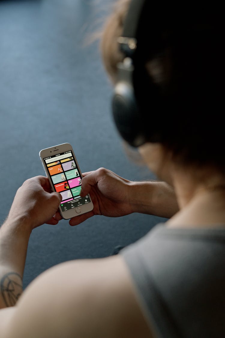 Person With Headphones Holding A Smartphone