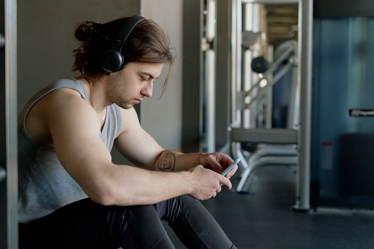 Athlete using a smartphone while resting inside a gym