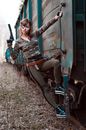 Confident female killer with gun hanging on train