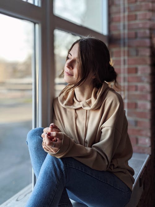 Woman Sitting on Windowsill