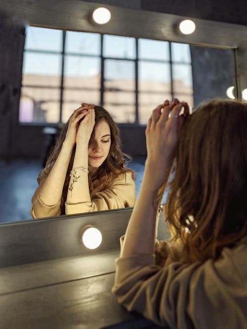 Free A Woman Sitting in Front of the Mirror Stock Photo