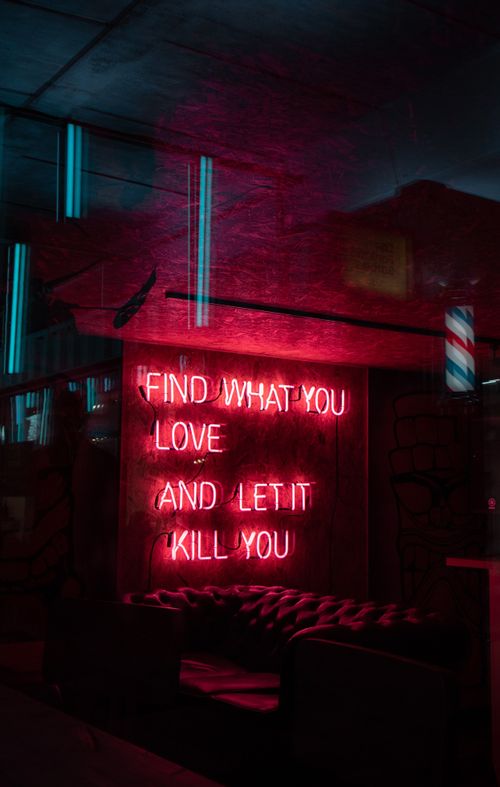 Free Vibrant neon sign displaying 'Find What You Love' in an urban setting at night. Stock Photo