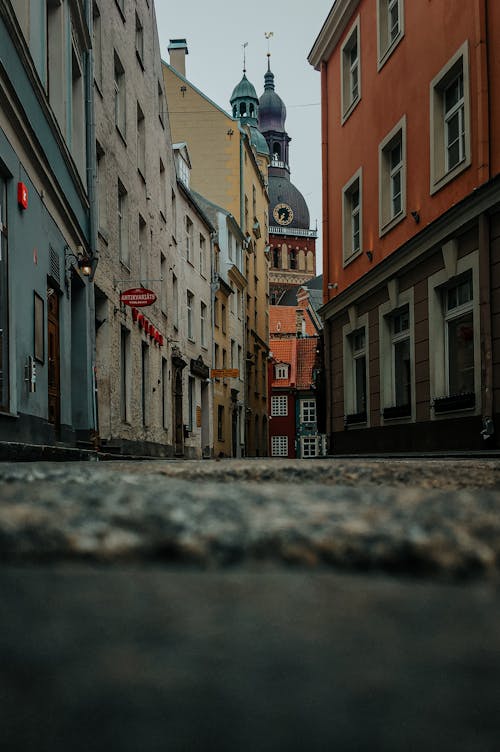 Ground level of empty narrow paved street between aged buildings leading to historical Cathedral Church of Saint Mary located in Riga