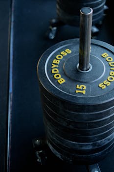 Closeup of Bodyboss weight plates stacked on a rack in a gym.