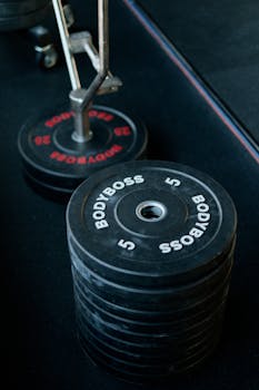 Close-up of stacked weight plates in a gym environment, emphasizing strength and fitness.