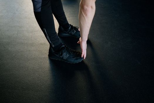 A person stretching in a gym, reaching down to touch their feet. Fitness and exercise concept.