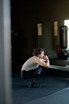 Man doing squats in a gym, focusing on fitness and strength training.