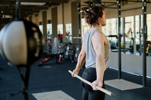 A man stretching with exercise equipment in a modern gym atmosphere, focusing on fitness.
