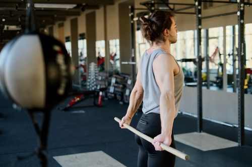 Free A man stretching with exercise equipment in a modern gym atmosphere, focusing on fitness. Stock Photo