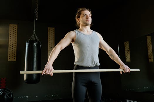 Athletic man exercising with stick in fitness gym, enhancing strength and coordination.