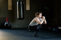 一名男子在时尚的健身房里拿着出气筒做深蹲