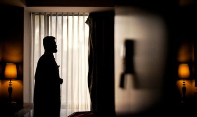 Silhouette of a man by a window in a dim room — Aman Uttam on Pexels