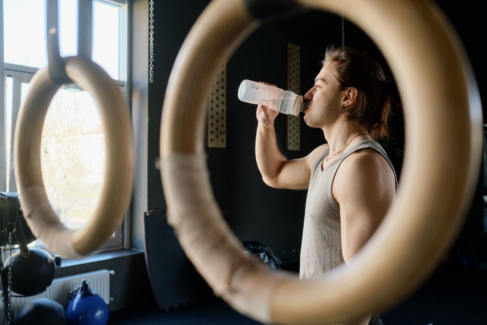 Water bottle with volume markers sitting beside workout gear