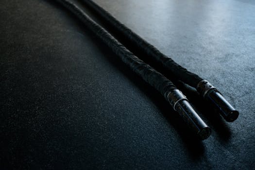 Close-up of battle ropes on a gym floor, ideal for fitness enthusiasts and training setups.