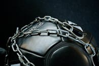 特写镜头聚焦于用金属链条包裹的重型健身器材，突出其力量与韧性