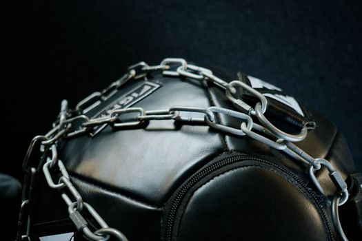 特写镜头聚焦于用金属链条包裹的重型健身器材，突出其力量与韧性