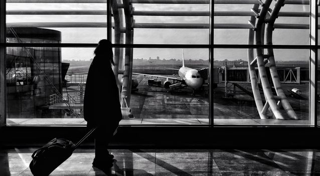 Silhouette of a traveler walking in Naya Raipur airport terminal, India.