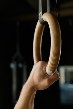 A focused shot of a hand gripping a gymnastic ring, highlighting strength and fitness.