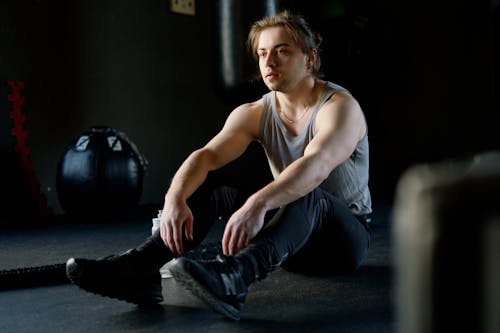 Man in a Tank Top Sitting on the Floor