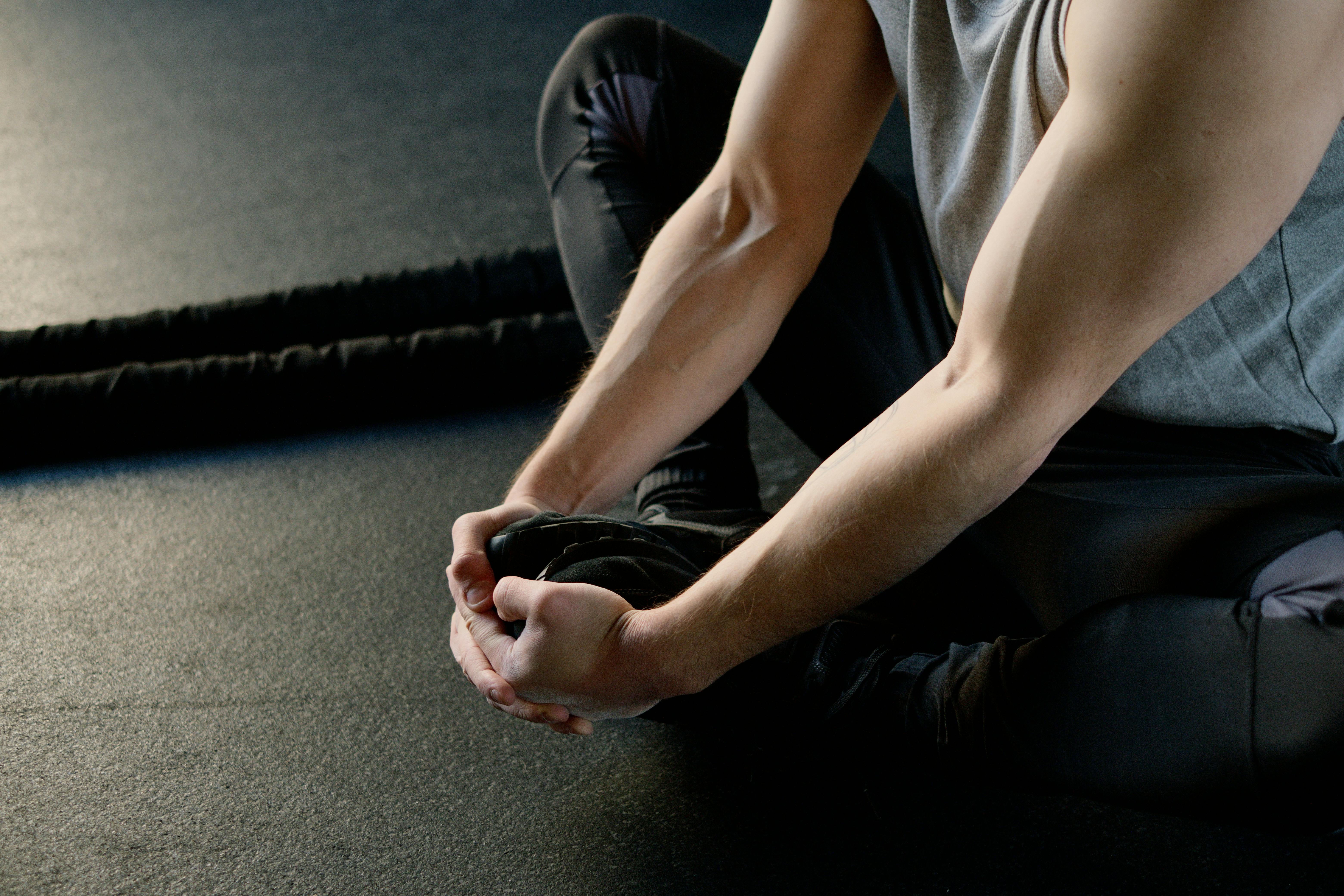 strong man sitting on the floor stretching