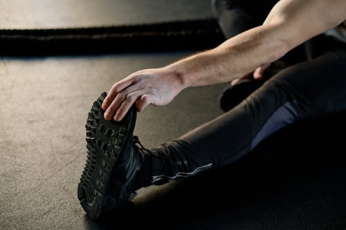 Free Person Holding his Foot and Stretching  Stock Photo