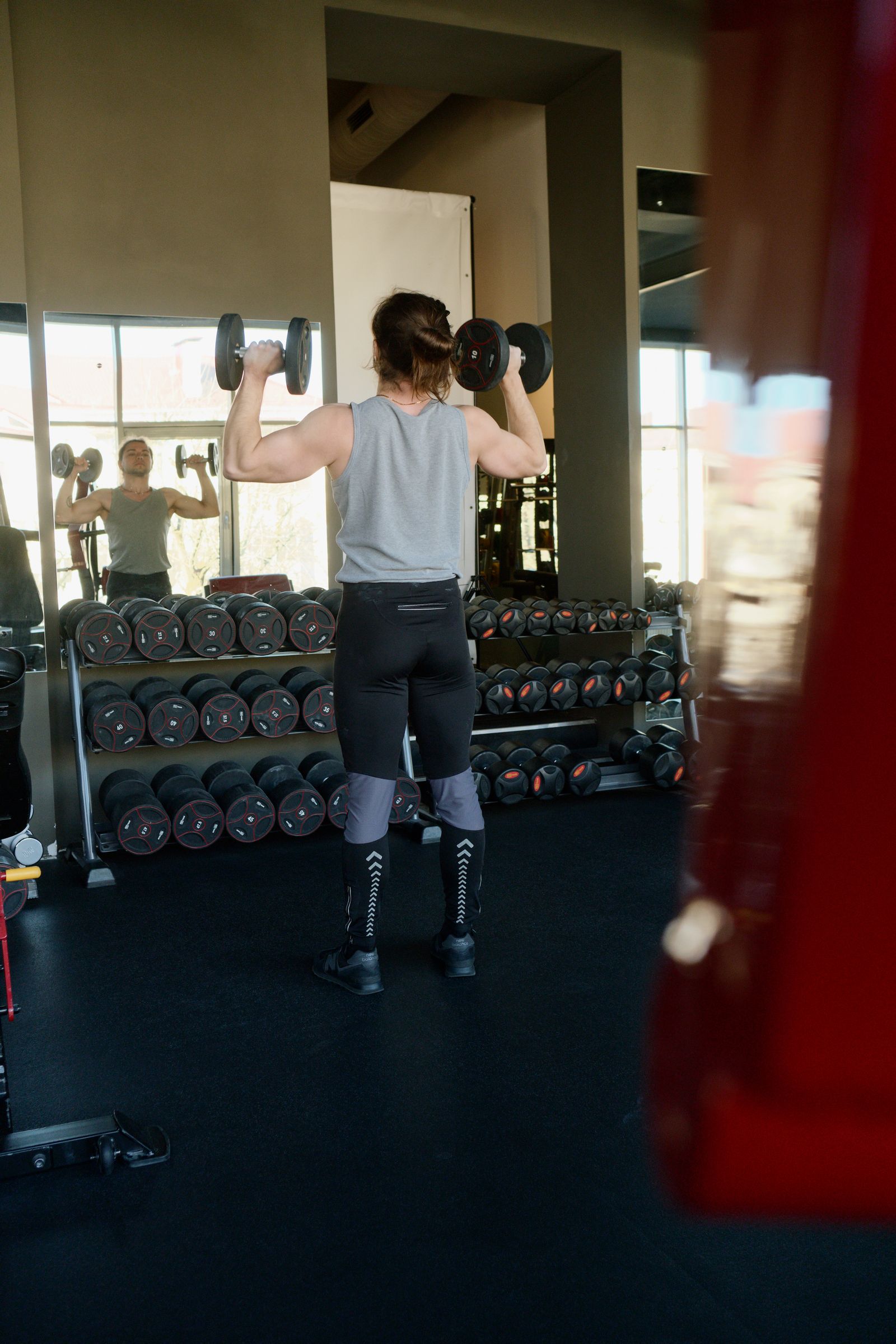 Man strength training with dumbbells in a gym