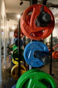 Stack of colorful weight plates in a modern gym, perfect for fitness enthusiasts.