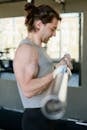 一名意志坚定的男子在健身房举起哑铃，展现着健康与力量