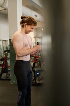 Determined man working out with exercise equipment in a modern gym setting.